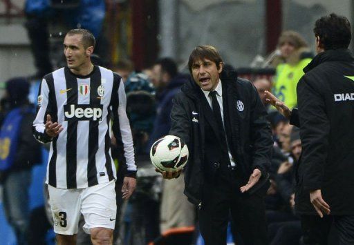 Juventus&#039; coach Antonio Conte gestures with a ball on March 30, 2013, at the San Siro stadium in Milan