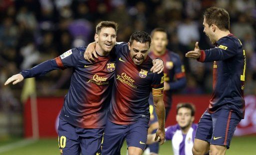 Barcelona&#039;s Xavi Hernandez (centre) celebrates with Lionel Messi after scoring against Valladolid on December 22, 2012