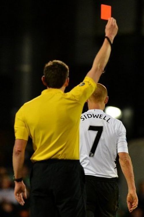 Fulham midfielder Steve Sidwell (R) receives a red card after tackling QPR defender Armand Traore on April 1, 2013