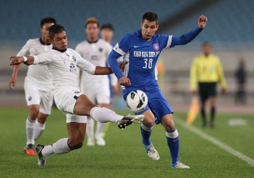 China Jiangsu Sainty&#039;s Aleksandar Jevtic (R) and Thailand Buriram United&#039;s Prathum Chutong on April 2, 2013