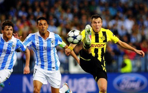 Malaga&#039;s Weligton (C) vies with Dortmund&#039;s Kevin Grosskreutz (R) in Malaga on April 3, 2013