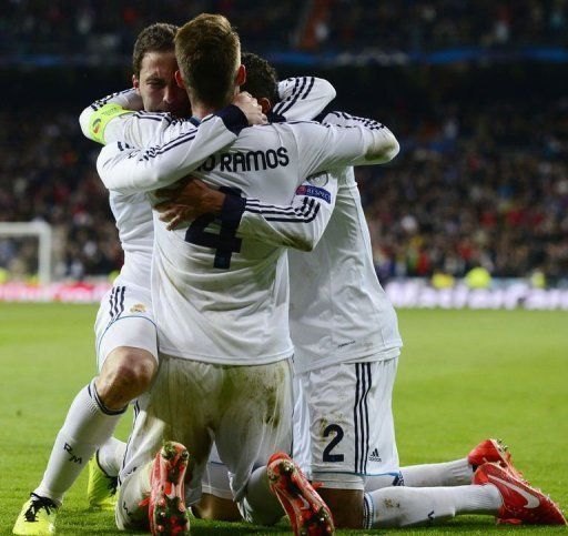 Real Madrid&#039;s Gonzalo Higuain (L) celebrates next to Raphael Varane (R) and Sergio Ramos on April 3, 2013 in Madrid
