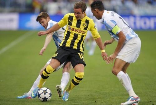 Borussia Dortmund midfielder Mario Goetze (C) dribbles past Malaga's Welington (R) and Antunes on April 3, 2013