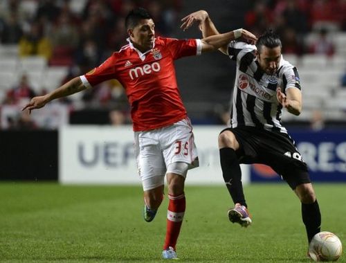 Newcastle's Jonas Gutierrez (R) tries to fend off a tackle from Benfica's Enzo Perez  on April 4, 2013