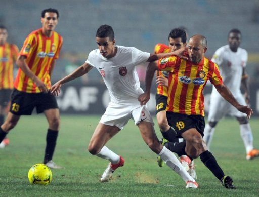 Etoile du Sahel&#039;s Aiman Belaid (left) vies with Esperance forward Khaled Mouelhi during a match in Tunis, August 5, 2012