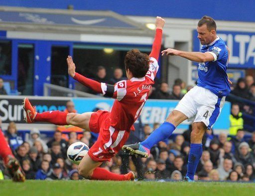 Everton&#039;s Darron Gibson (R) shoots to score the opening goal past Queens Park Rangers&#039; Park Ji-Sung, April 13, 2013