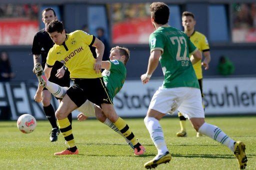 Dortmund&#039;s Robert Lewandowski (L) and Fuerth&#039;s Johannes Geis (C) fight for the ball in Fuerth, April 13, 2013