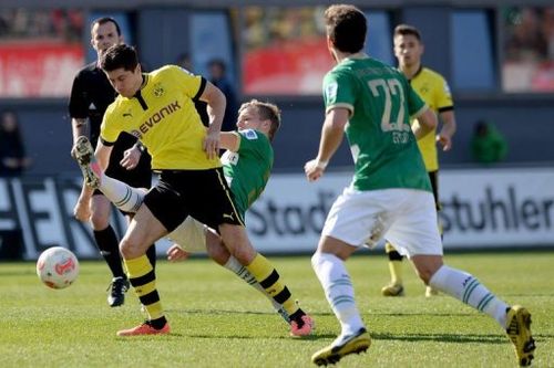 Dortmund's Robert Lewandowski (L) and Fuerth's Johannes Geis (C) fight for the ball in Fuerth, April 13, 2013