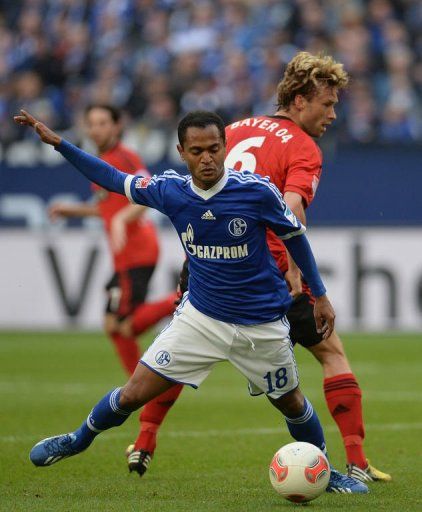 Schalke&#039;s Raffael (L) and Leverkusen&#039;s Simon Rolfes fight for the ball in Gelsenkirchen on April 13, 2013