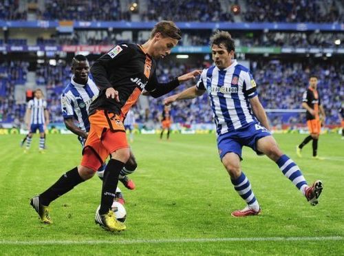 Valencia's Sergio Canales (L) fights for the ball with Espanyol's Victor Sanchez, April 13, 2013 in Cornella