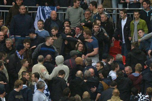 Millwall fans fight in the crowd during the match between Millwall and Wigan Athletic at Wembley Stadium, April 13, 2013