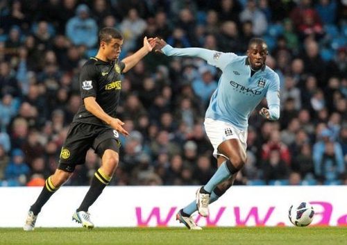 Manchester City's Yaya Toure (R) races for the ball against Wigan's Franco Di Santo in Manchester on April 17, 2013.