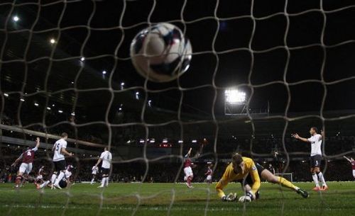 Manchester United's goalkeeper David de Gea (2nd R) watches as the ball hits the back of his net on April 17, 2013