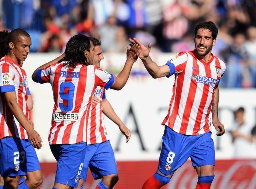 Atletico Madrid&#039;s Raul Garcia (R) is congratulates by teammates after scoring against Granada, on April 14, 2013