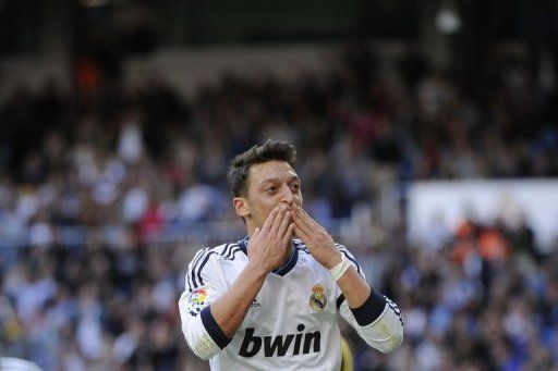 Real Madrid&#039;s midfielder Mesut Ozil celebrates after scoring at the Santiago Bernabeu stadium in Madrid, April 20, 2013