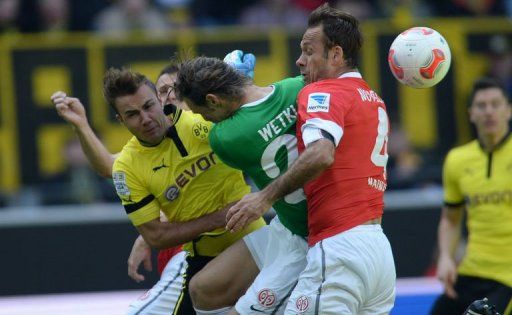 Dortmund&#039;s Mario Goetze goes for the ball against Mainz&#039; Christian Wetklo (C) and Nikolce Noveski, April 20, 2013