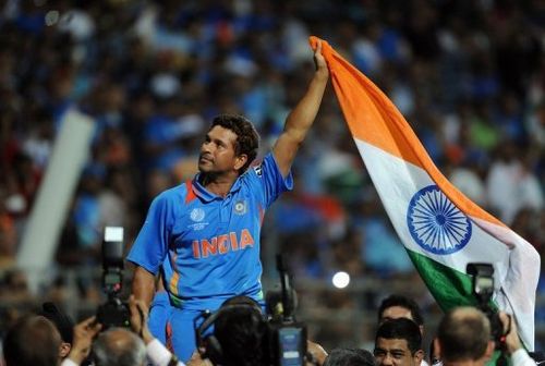 Sachin Tendulkar waves the Indian flag as he celebrates his team's World Cup win on April 2, 2011