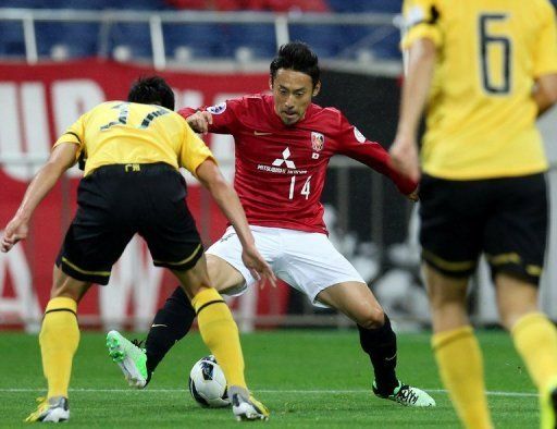 Urawa Red Diamonds&#039; Tadaaki Hirakawa (C) is blocked by Guangzhou Evergrande players in Saitama, Tokyo on April 24, 2013