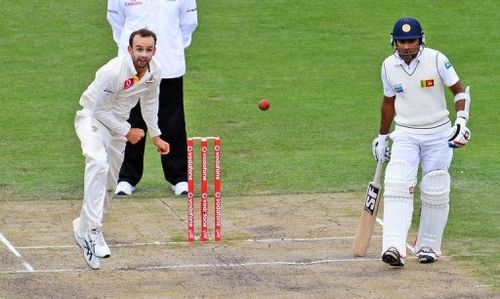 Australian Test spinner Nathan Lyon (L) bowls a delivery during their Sri Lanka Test in Hobart on December 17, 2012