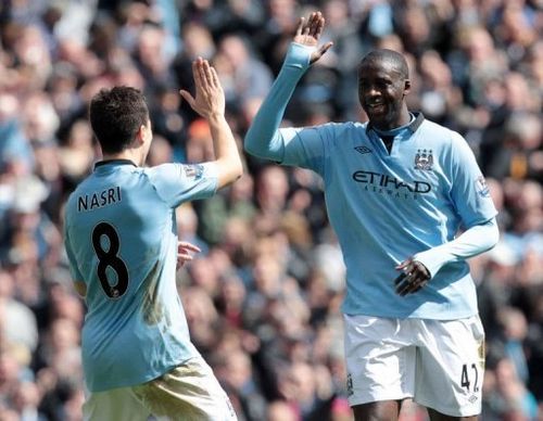 Manchester City's Yaya Toure (R) celebrates his goal against West Ham with Samir Nasri in Manchester, April 27, 2013