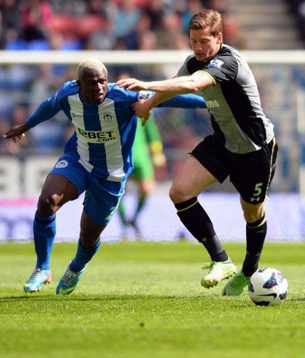 Wigan striker Arouna Kone (L) tussles with Tottenham defender Jan Vertonghen on April 27, 2013