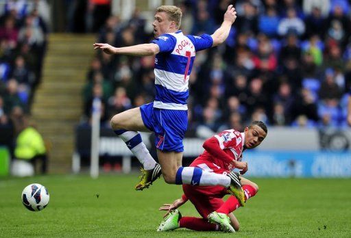 Reading striker Pavel Pogrebnyak (L) skips away from Jermaine Jenas during the match against QPR on April 28, 2013