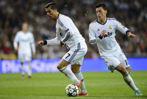 Real Madrid&#039;s Cristiano Ronaldo (L) controls the ball next to Mesut Ozil in Madrid on April 30, 2013