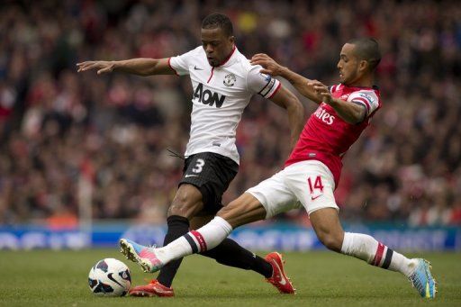 Arsenal forward Theo Walcott (R) challenges Manchester United&#039;s French defender Patrice Evra on April 28, 2013