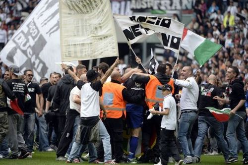 Juventus' supporters stand on the pitch after their team defeated Palermo to win the Scudetto on May 5, 2013 in Turin