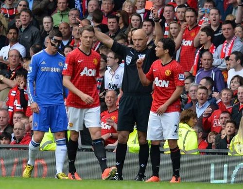 Referee Howard Webb shows a red card to Manchester United defender Rafael da Silva (R) at Old Trafford, on May 5, 2013