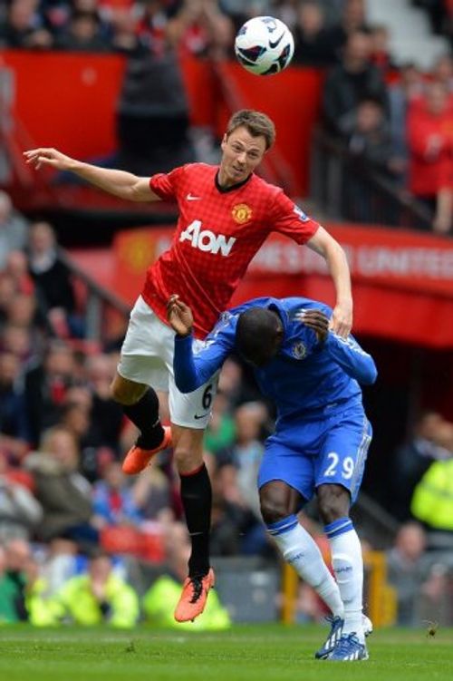 Chelsea's Demba Ba (R) ducks as Manchester United defender Jonny Evans makes an acrobatic clearance  on May 5, 2013