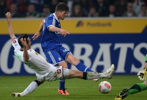 Schalke's Klaas-Jan Huntelaar is tackled by Moenchengladbach's Martin Stranzl during their Bundesliga match, May 3, 2013