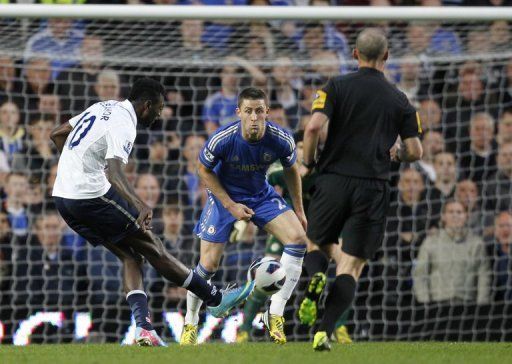 Tottenham Hotspur&#039;s Emmanuel Adebayor (L) shoots to score past Chelsea defender Gary Cahill on May 8, 2013
