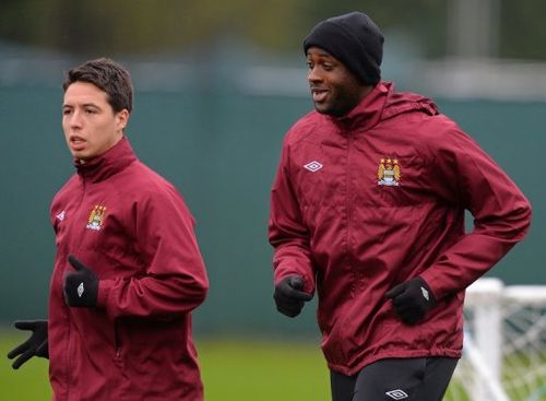 Manchester City's  Samir Nasri (L) and  Yaya Toure warm up during a training session, on May 10, 2013