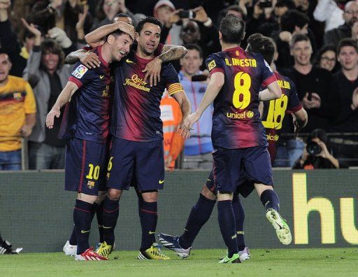Barcelona&#039;s Lionel Messi (L) is congratulated after scoring against Real Betis on May 5, 2013
