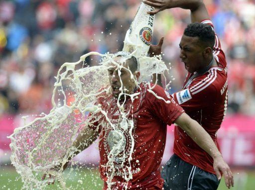 Bayern Munich&#039;s Jerome Boateng (R) pours beer on Franck Ribery while celebrating their title in Munich, on May 11, 2013