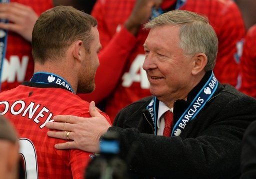 Alex Ferguson (R) pats Wayne Rooney on the shoulder at Old Trafford in Manchester on May 12, 2013