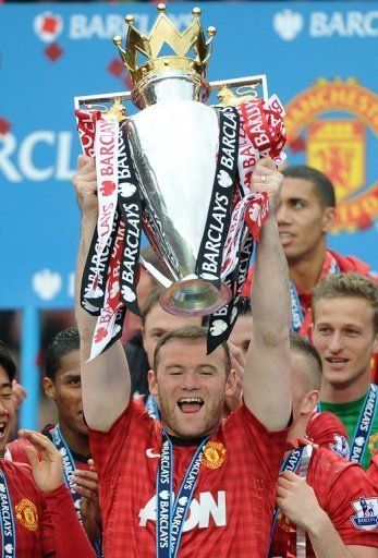 Manchester United striker Wayne Rooney lifts the Premier League trophy at Old Trafford in Manchester on May 12, 2013
