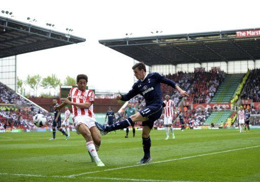 Tottenham Hotspur&#039;s Gareth Bale (R) crosses the ball past Stoke City&#039;s Ryan Shotton during their match on May 12, 2013