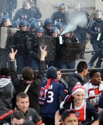 Paris Saint Germain supporters clash with riot police on May 13, 2013 in Paris