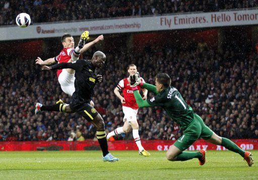 Laurent Koscielny (L) and goalkeeper Wojciech Szczesny (R) defend the Arsenal goal post on May 14, 2013