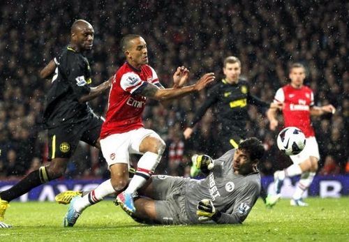 Theo Walcott (C) scores Arsenal's second goal during their Premier League match against Wigan on May 14, 2013