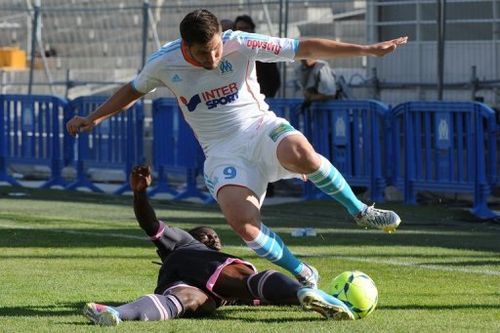 Marseille's Andre Pierre Gignac (R) fights for the ball with Toulouse's Serge Aurier, in Marseille, on May 11, 2013