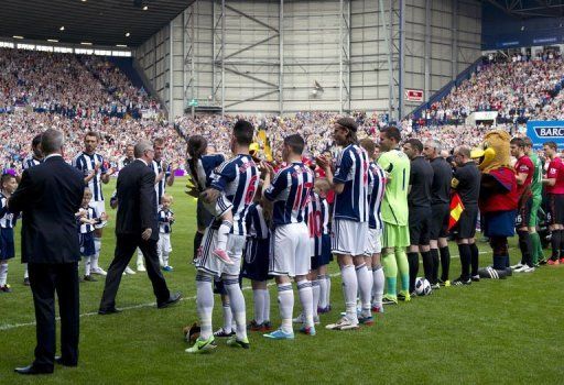 Alex Ferguson is greeted by players in West Bromwich on May 19, 2013
