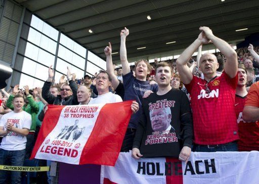 Manchester United fans sing after their team scores a goal at West Bromwich, on May 19, 2013