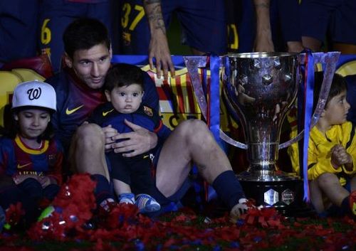 Barcelona's Lionel Messi holds his son Thiago during a ceremony at the Camp Nou stadium in Barcelona on May 19, 2013