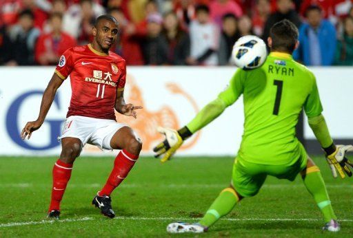 Guangzhou Evergrande&#039;s Muriqui (L) shoots past Mariners goalkeeper Mathew Ryan during their game on May 15, 2013