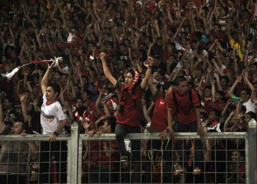 Spectators shout slogans during Indonesia&#039;s Asian Cup home qualifier against Saudi Arabia on March 23, 2013