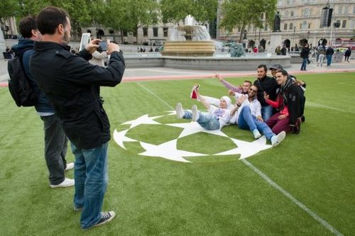 People take photos in a 'football fan zone' at Trafalgar Square in London, on May 22, 2013