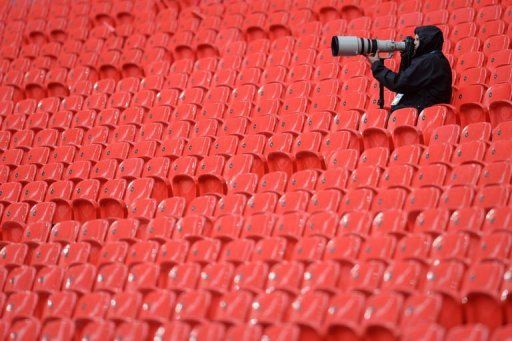 A photographer sits in the stands following a Bayern Munich training session at Wembley Stadium in London, May 24, 2013